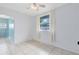 This bedroom features white walls, tiled flooring, and natural light from the large window at 6305 Bass Hwy, St Cloud, FL 34771