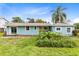 Charming single-story home featuring a vibrant yellow door and a well-maintained front yard with lush landscaping at 6305 Bass Hwy, St Cloud, FL 34771