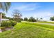 Well-manicured front yard with lush green grass, mature trees, and a distant lake view at 6305 Bass Hwy, St Cloud, FL 34771