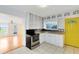 Well-lit kitchen with white cabinetry, stainless steel appliances, and a unique yellow door for a pop of color at 6305 Bass Hwy, St Cloud, FL 34771