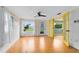 Sunlit living room featuring gleaming hardwood floors, large windows, and unique yellow doors, offering a blend of style and comfort at 6305 Bass Hwy, St Cloud, FL 34771