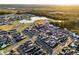 Aerial view of a planned community featuring new homes, green spaces, streets, and a lake at 6439 Trailblaze Bnd, St Cloud, FL 34771