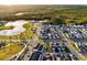 An aerial perspective highlights a community with a lake, lush greenery, walking paths, and stylishly designed residences at 6439 Trailblaze Bnd, St Cloud, FL 34771