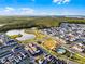 Aerial shot of a vibrant community featuring modern homes, a scenic lake, extensive parklands, and a community pool at 6439 Trailblaze Bnd, St Cloud, FL 34771