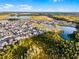 Wide aerial view of a neighborhood with green spaces, homes, and lakes in a suburban community at 6439 Trailblaze Bnd, St Cloud, FL 34771
