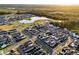 This aerial view showcases a Primary-planned community with modern homes and a central lake, surrounded by green spaces at 6439 Trailblaze Bnd, St Cloud, FL 34771