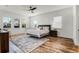 Bright bedroom featuring wood floors, a ceiling fan, and large windows with natural light at 6439 Trailblaze Bnd, St Cloud, FL 34771