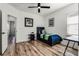 Cozy bedroom featuring wood floors, ceiling fan, and natural light from a window at 6439 Trailblaze Bnd, St Cloud, FL 34771