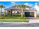 Beautiful two-story home featuring a dark gray two-car garage, solar panels, and manicured landscaping at 6439 Trailblaze Bnd, St Cloud, FL 34771