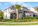 Two-story home with a mix of siding colors, a covered porch, solar panels, and manicured landscaping at 6439 Trailblaze Bnd, St Cloud, FL 34771