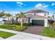 Stunning two-story home featuring lush landscaping, a well-manicured lawn, and a paver driveway at 6439 Trailblaze Bnd, St Cloud, FL 34771