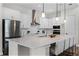 Modern kitchen featuring a large island with bar seating, stainless steel appliances, and white cabinetry at 6439 Trailblaze Bnd, St Cloud, FL 34771