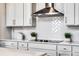 Close-up of kitchen with subway tile backsplash, stainless range hood, and cooktop at 6439 Trailblaze Bnd, St Cloud, FL 34771