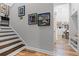 Stairway featuring wood stairs leading to a landing with wall decor and an adjacent seating area at 6439 Trailblaze Bnd, St Cloud, FL 34771