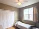 Bedroom with hardwood floors, closet, ceiling fan, and window with light filtering curtains at 6575 Time Square Ave # 101, Orlando, FL 32835