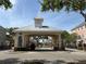 Welcoming community entrance with clock tower feature and manicured landscaping at 6575 Time Square Ave # 101, Orlando, FL 32835