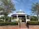 A well-maintained community gazebo with manicured hedges and a brick pathway at 6575 Time Square Ave # 101, Orlando, FL 32835