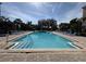 An inviting community pool surrounded by comfortable seating and lush landscaping at 6575 Time Square Ave # 101, Orlando, FL 32835