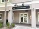 Exterior view of the community fitness center entrance with a modern sign and landscaping at 6575 Time Square Ave # 101, Orlando, FL 32835