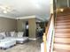 Inviting living room with wood stairs featuring an open floor plan and adjacent breakfast bar at 6575 Time Square Ave # 101, Orlando, FL 32835
