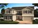 Charming two-story home featuring a manicured lawn, neutral paint, dark shutters, and a two-car garage at 7264 Dilly Lake Ave, Groveland, FL 34736