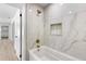 Luxurious bathroom featuring a white marble tile shower and a soaking tub with a gold shower head at 7320 Fieldcrest Ave, Winter Park, FL 32792