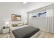 Airy bedroom featuring neutral decor, matching nightstands, and large window with natural light at 7320 Fieldcrest Ave, Winter Park, FL 32792