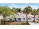 Charming single-story home with a beautifully landscaped front yard and mature palm trees at 7320 Fieldcrest Ave, Winter Park, FL 32792