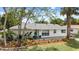 Charming single-story home boasts a beautifully landscaped front yard and an inviting entrance at 7320 Fieldcrest Ave, Winter Park, FL 32792