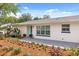 Charming single-story home with a beautifully landscaped front yard, featuring colorful plants at 7320 Fieldcrest Ave, Winter Park, FL 32792