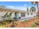 Charming single-story home with a beautifully landscaped front yard and inviting teal-colored front door at 7320 Fieldcrest Ave, Winter Park, FL 32792