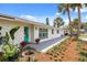 Close-up of the front entrance with a gray walkway, colorful flowers, and a bright turquoise door at 7320 Fieldcrest Ave, Winter Park, FL 32792