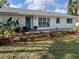 Charming home with a beautifully landscaped front yard and a bright blue front door at 7320 Fieldcrest Ave, Winter Park, FL 32792
