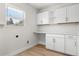 Bright laundry room featuring white cabinets, countertop, and window with natural light at 7320 Fieldcrest Ave, Winter Park, FL 32792