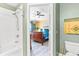 Bathroom leading to a bedroom featuring a tub-shower combo, and a ceiling fan at 7666 Sir Kaufmann Ct, Kissimmee, FL 34747