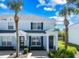 Two-story townhome with light blue facade, dark shutters, and palm trees at 7666 Sir Kaufmann Ct, Kissimmee, FL 34747