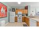 Kitchen with wood cabinets, white appliances, and decoratively adorned countertops at 7666 Sir Kaufmann Ct, Kissimmee, FL 34747
