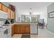 Open kitchen with light wood cabinets, white appliances, and a view into the living area at 7666 Sir Kaufmann Ct, Kissimmee, FL 34747