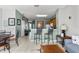 Living area showcasing an open floor plan with a kitchen bar and decorative wall art at 7666 Sir Kaufmann Ct, Kissimmee, FL 34747