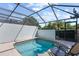 Screened-in pool with brick trim, lounge chairs, and privacy wall offers a relaxing outdoor space at 7666 Sir Kaufmann Ct, Kissimmee, FL 34747