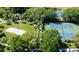 Aerial view of tennis and basketball courts, with a volleyball court and walking paths, all nestled in lush greenery at 7666 Sir Kaufmann Ct, Kissimmee, FL 34747