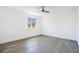 Bright bedroom features wood-look flooring, ceiling fan and a sunlit window at 10124 Shadow Leaf Ct, Orlando, FL 32825