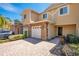 Townhouse exterior featuring stone accents, a two-car garage, and a brick-paved driveway at 10124 Shadow Leaf Ct, Orlando, FL 32825