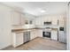Bright kitchen features white cabinets, stainless steel appliances, and wood-look flooring at 10124 Shadow Leaf Ct, Orlando, FL 32825