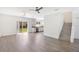 Open-concept living area with wood-look flooring, stairs, and sliding doors to the backyard at 10124 Shadow Leaf Ct, Orlando, FL 32825