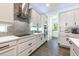 Well-appointed kitchen featuring stainless steel appliances, white cabinets, stylish backsplash, and wood-look tile flooring at 10255 Beechwood Ln, Orlando, FL 32832