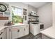 Bright laundry room featuring a sink, modern appliances, and ample counter space at 10255 Beechwood Ln, Orlando, FL 32832