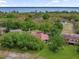 Aerial view of a community with tile roofs, lush landscaping and trees, close to lake at 112 Coventry Ln, Haines City, FL 33844