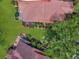 Aerial view showcases the home's expansive tile roof, manicured lawn, screened-in lanai and tropical landscaping at 112 Coventry Ln, Haines City, FL 33844