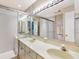 Well-lit bathroom featuring a double vanity sink, a large mirror, and tiled floors and shower at 112 Coventry Ln, Haines City, FL 33844